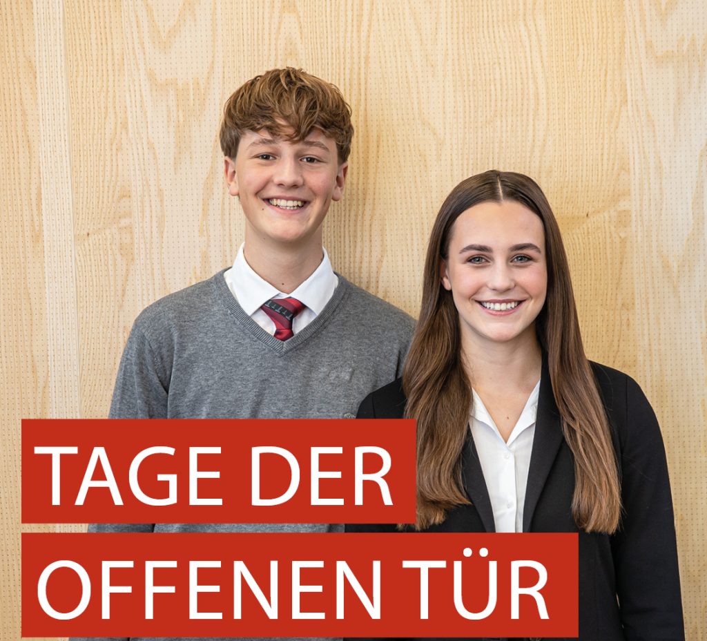 Schild, das den Tag der offenen Tür in der Tourismusschule Klessheim am 14. und 15. November ankündigt, mit zwei Personen in Geschäftskleidung dahinter.