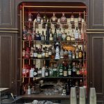 Ein Barregal, auf dem Spirituosenflaschen, Gläser und Cocktail-Shaker angeordnet sind.