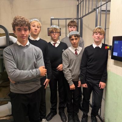 Eine Gruppe von Jungen in Schuluniformen, von denen einige Mützen mit ausgefallenen Schnitten tragen, wodurch die Stile der Uniformen und Mützen besonders zur Geltung kommen.