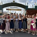 Trachtengruppe junger Leute vor Festzelt-Eingang auf einem Volksfest in Österreich.