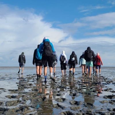 Menschen mit Rucksäcken bei einem Erasmus+ Wittmund Abenteuer.