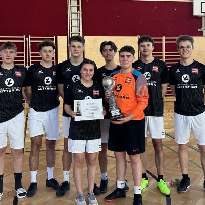 Eine Gruppe junger Athleten posiert nach dem Hallenfußballturnier TS mit einer Urkunde und einem Pokal.