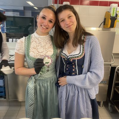Käseteller, die während der Käsekenner-Prüfungen auf einem Tisch ausgestellt sind, hinter dem Menschen stehen.