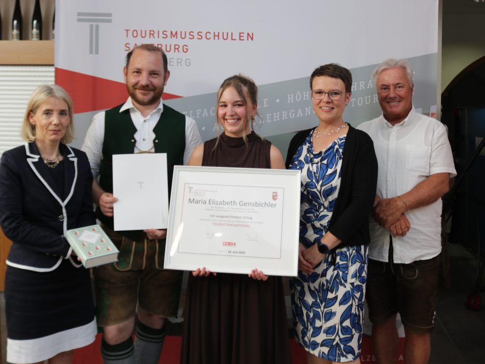 Fünf Personen bei einer Preisverleihung, in deren Mitte eine Urkunde für die Maturaklasse und Abschlussklasse 2025 ausgestellt ist.