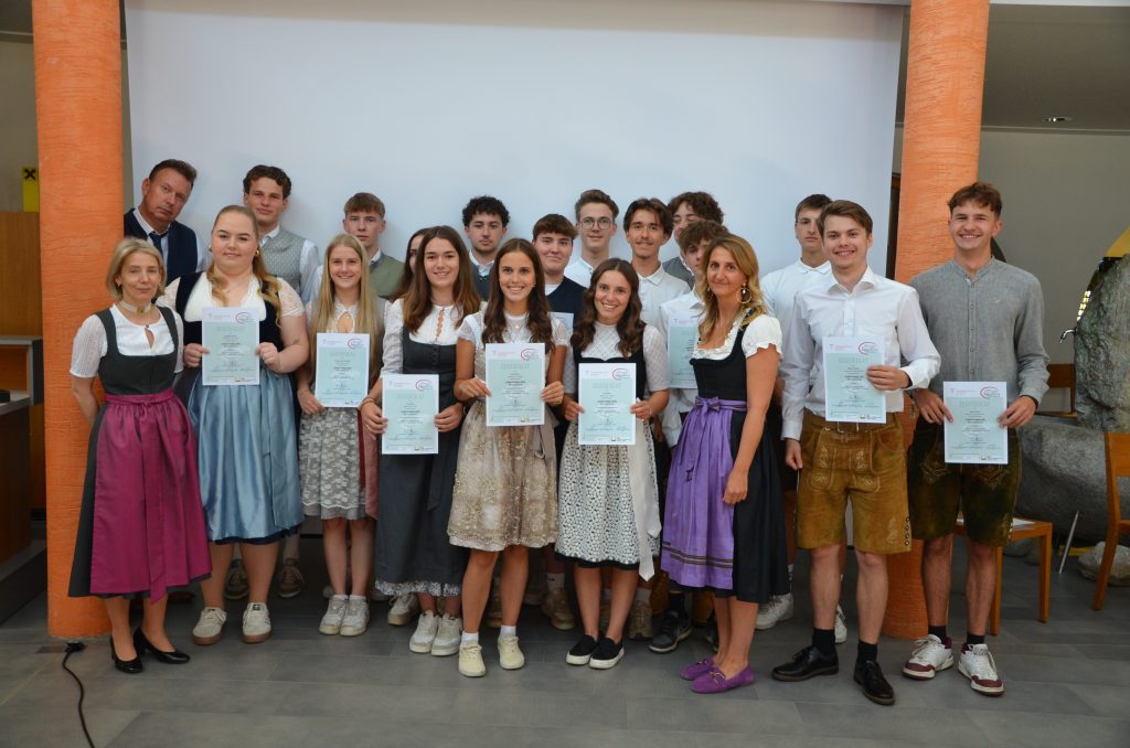 Die Finalisten des Wettbewerbs „Jungsommelier Österreich 2019“ posieren in traditioneller bayerischer Tracht und halten ihre Urkunden in den Händen.
