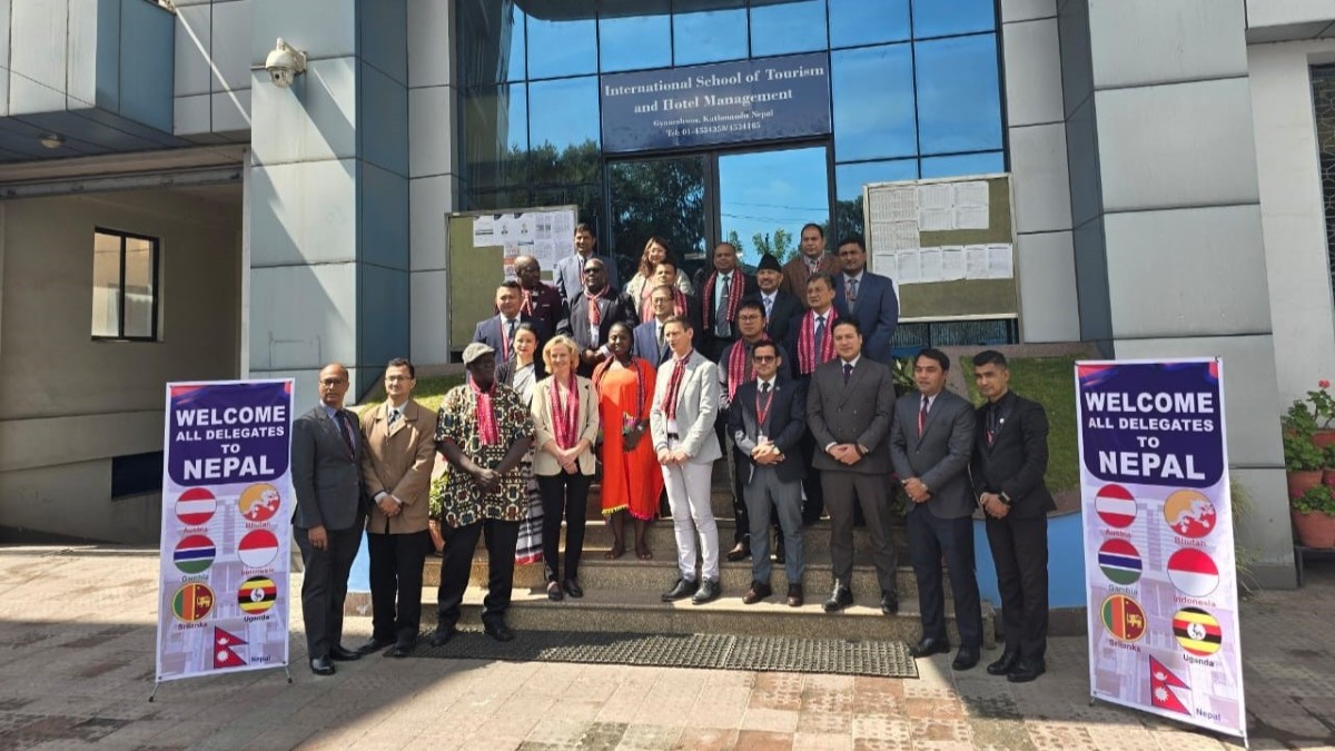 Die Delegierten posieren vor der International School of Tourism and Hotel Management, mit Willkommensbannern am Eingang. Die Delegierten posieren vor der International School of Tourism and Hotel Management, mit Willkommensbannern am Eingang.